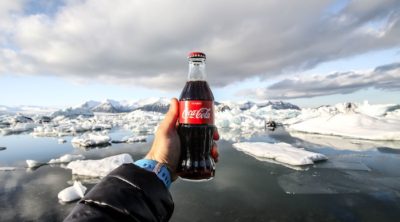 Shot of hand holding Coca Cola bottle in arctic climate.