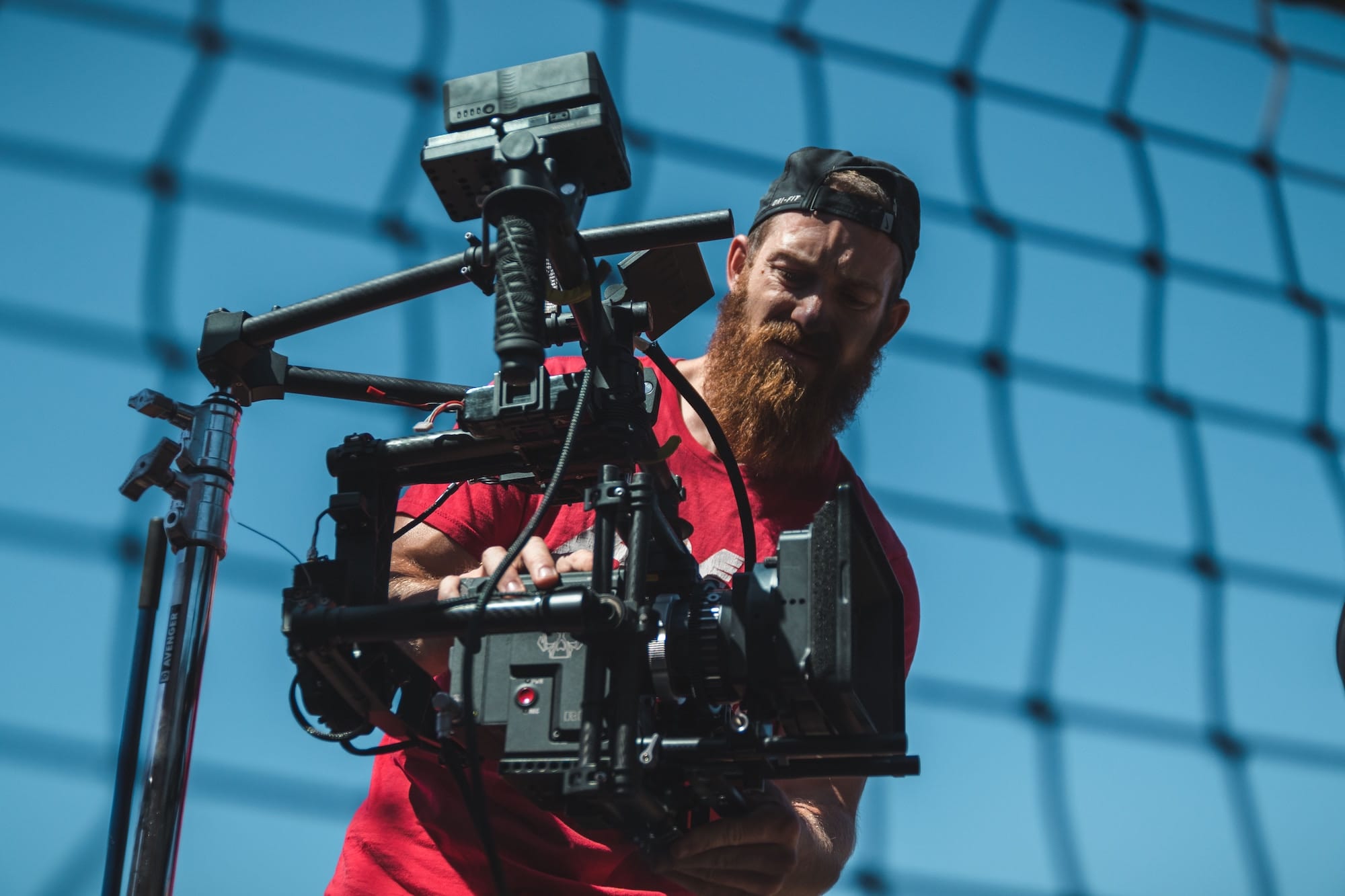 Bearded man holding camera set up. 